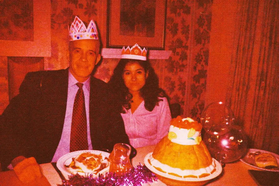 A couple in paper crowns at a Christmas table in 1974