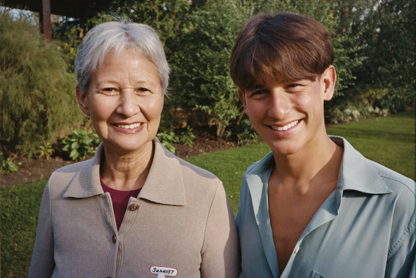 A mother and her adult son in a garden, with tag boxes drawn over their faces